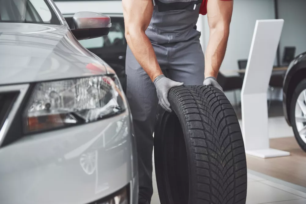 mechanic-holding-tire-tire-repair-garage-replacement-winter-summer-tires