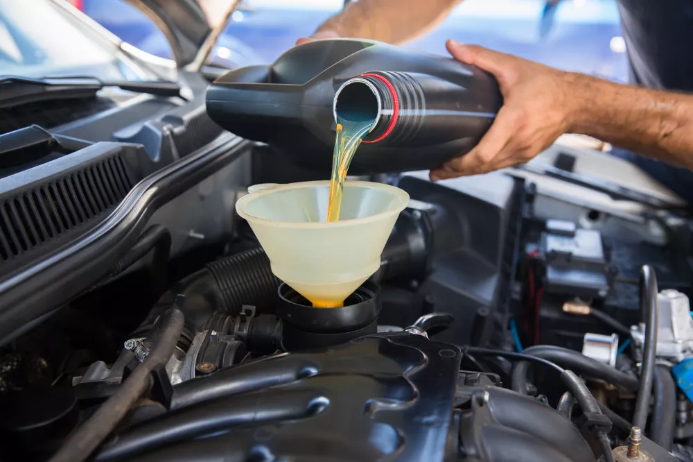car-mechanic-replacing-pouring-fresh-oil