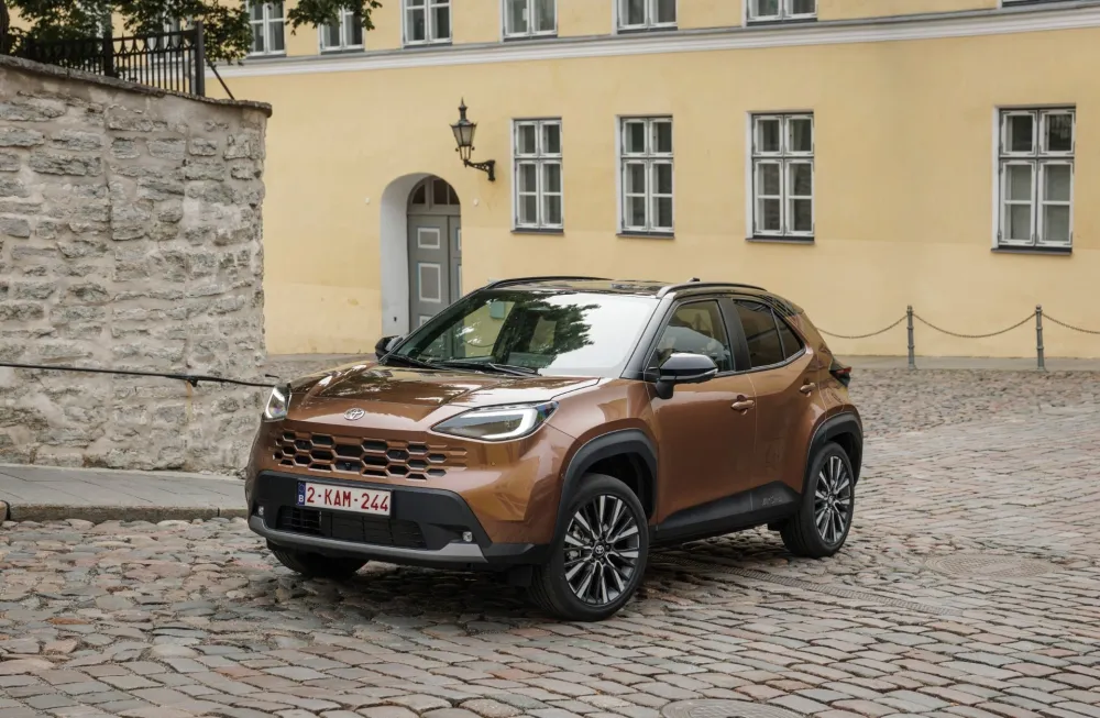 Toyota Yaris Cross po modernizacji w kolorze Precious Bronze na miejskiej ulicy.
